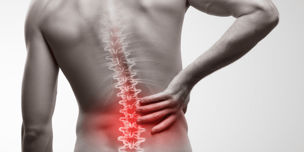 A man holding his lower back in pain surrounded by redness.